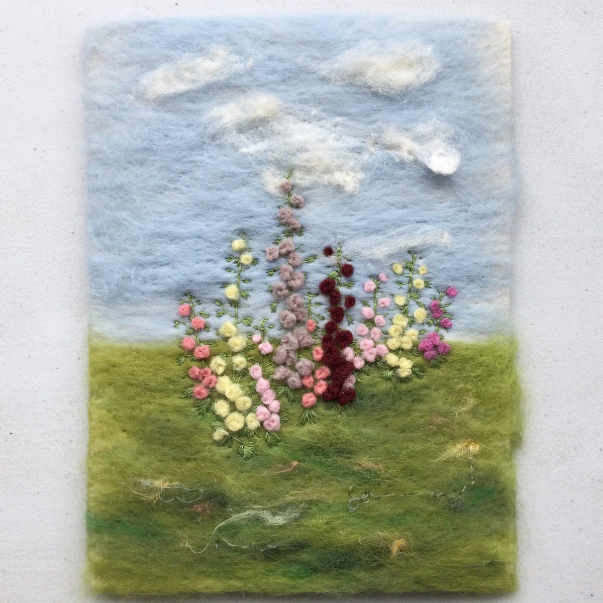 Finished hollyhock picture. Loved creating the flowers by needle felting tiny balls of merino wool. #hollyhock #textileartist #summerart #floralart #giftideas #gardeninspiration
