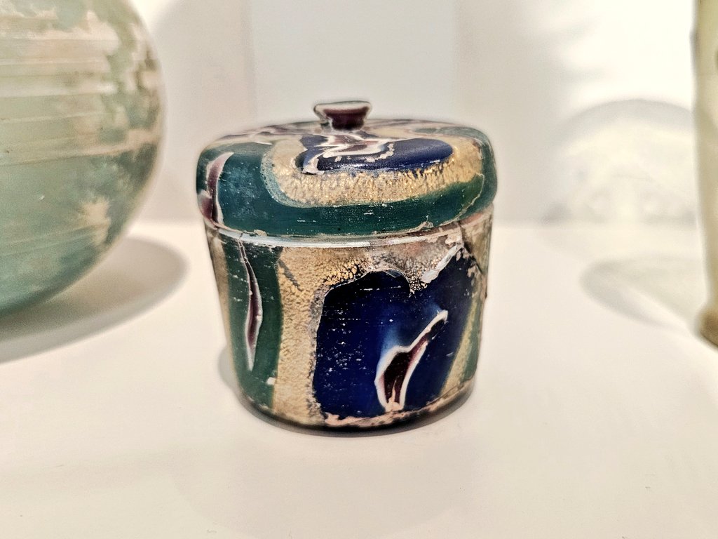 The gold-band pyxis is an amazing example of Roman luxury glassware. It combines canes of brightly colored glass with strips of gold leaf encased between layers of colorless glass.
It was used to hold cosmetics. 
Dating 1st c. AD.
On display at Altes Museum Berlin

📷 taken by me