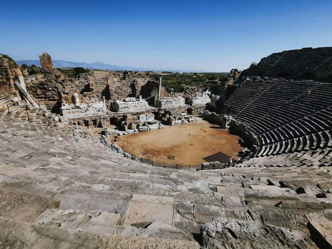 Roman theatre, located in Side a city on southern Mediterranean coast of Türkiye. Side was founded by Greek settlers in western Anatolia, this most likely occurred in the 7th Century BC, Its main deity was Athena. Theatre is the greatest preserved historical building in the