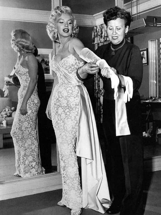 Marilyn Monroe being dressed in Travilla by hairstylist Gladys Rasmussen for the 'How To Marry A Millionaire' premiere in 1953.