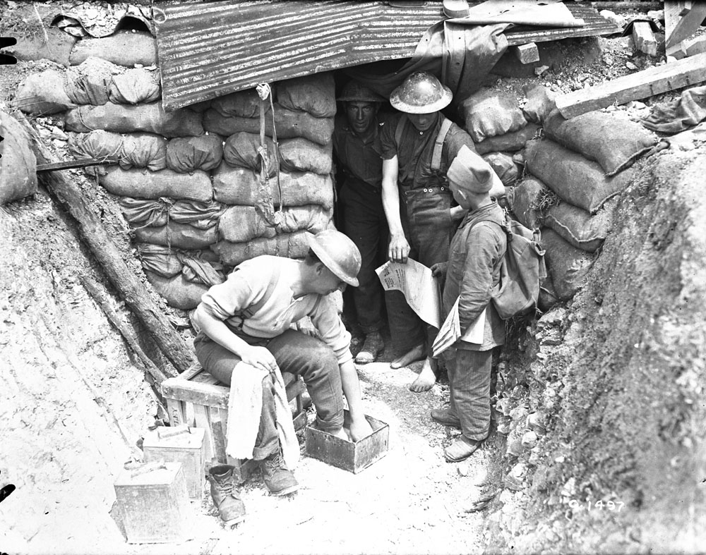 A French paper boy selling English papers to Canadian Soldiers in June, 1917. // Un livreur de journaux français vend des journaux anglais aux soldats canadiens en juin 1917.