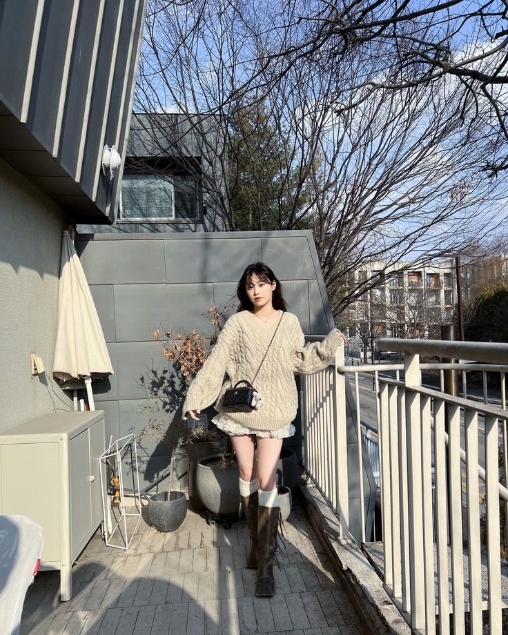 Beneath the hem of her sweater, a delicate lace skirt peeks out, a whisper of spring in the heart of winter. It flutters with her every movement, a testament to her youthful exuberance and the timeless elegance that she effortlessly embodies.