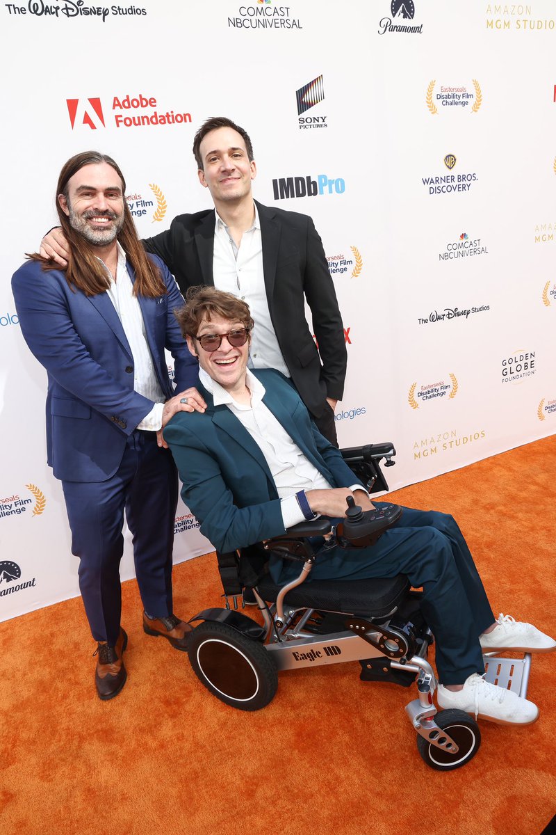 EDFC 2024 Best Film, Best Writer, and Best Awareness nominated film “Wheelchair Club” crew pose on the Orange Carpet. Thanks for making a great film!

ID: @joshflanagan in a blue suit stands next to @zach.anner in a blue suit who sits in his wheelchair next to @chrisdemarais