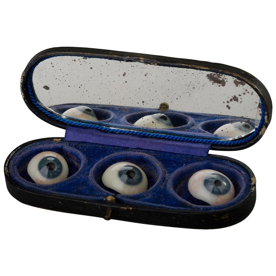 Three glass eyes with portable velvet carrying case and mirror, c.1870. These were likely meant to be carried by an ocularist – someone who specialized in making and fitting prosthetic eyes – to assist them in making the best possible match to the patient’s remaining eye.