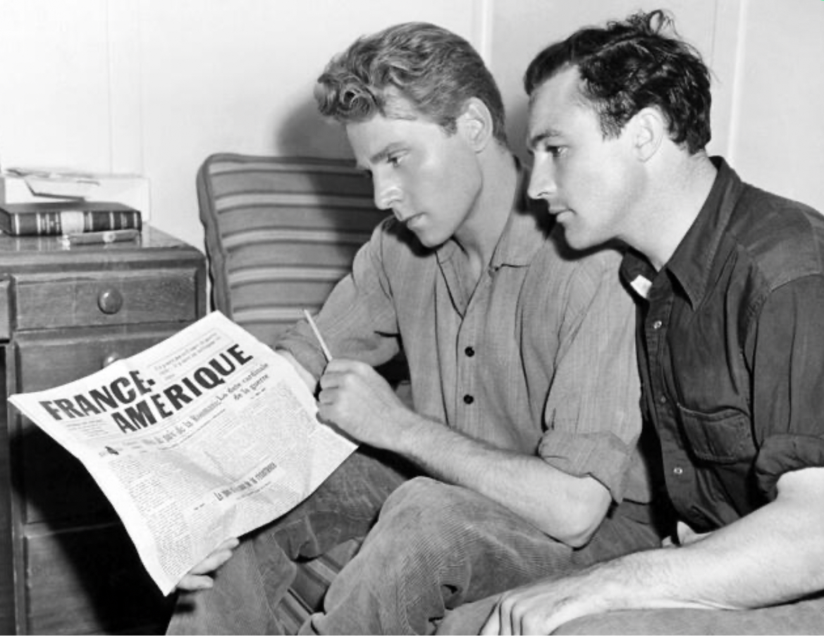 Jean-Pierre Aumont and Gene Kelly on a break during filming of THE CROSS OF LORRAINE (1943), directed by Tay Garnett at MGM