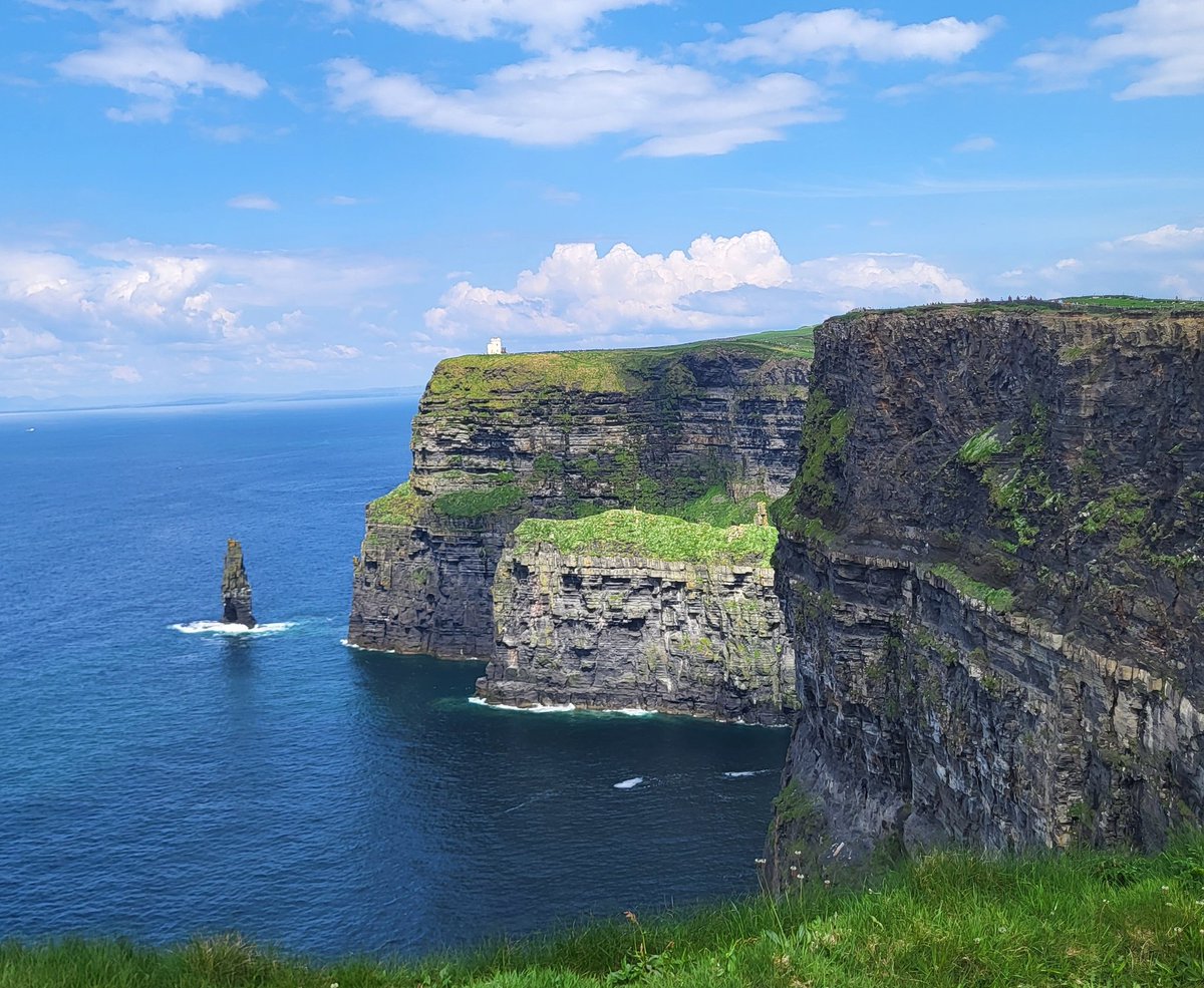 Cliffs of Moher, with the sun shining on Goat Island - home to the largest Atlantic Puffin (Fratercula arctica) colony on the Cliffs. County Clare, Ireland.