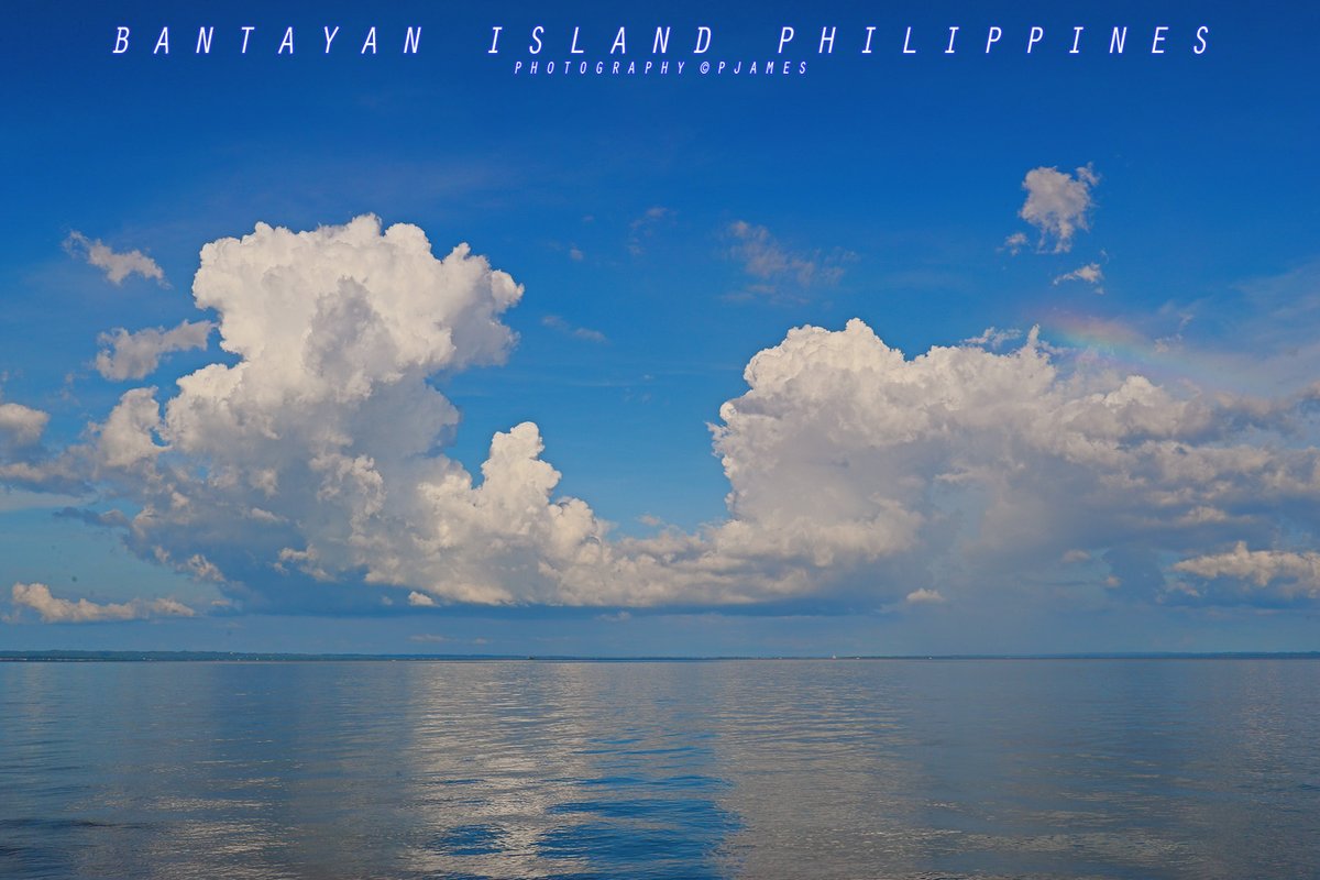 Island Life Therapy: Huge cumulus clouds frame a tiny rainbow on the right, against a Gorgeous Blue Sky:  Bantayan Island Cebu, The Philippines. #ThePhotoHour #travelphotography #IslandLife #bantayanisland #bantayan #photography #EOS #StormHour #ShotOnCanon #weather @TourismPHL