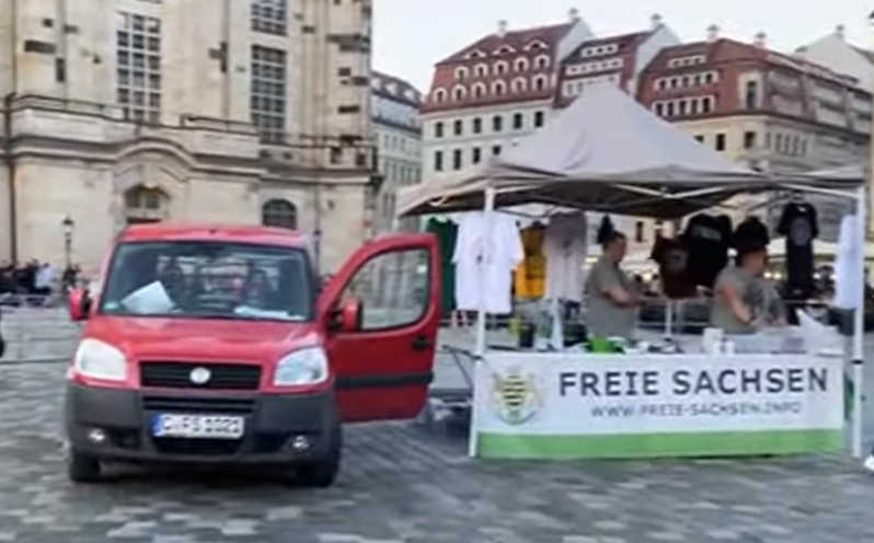 PoGeSachsen's tweet photo. Natürlich durften auch heute die extrem rechten Freien Sachsen auf der Kundgebungsfläche von Pegida einen ihrer bekannten 'Infostände' aufbauen, bei dem sie rechtsextremen Merch und braune #Propaganda vertreiben. #DD2005 https://t.co/UEYM1FP8xr