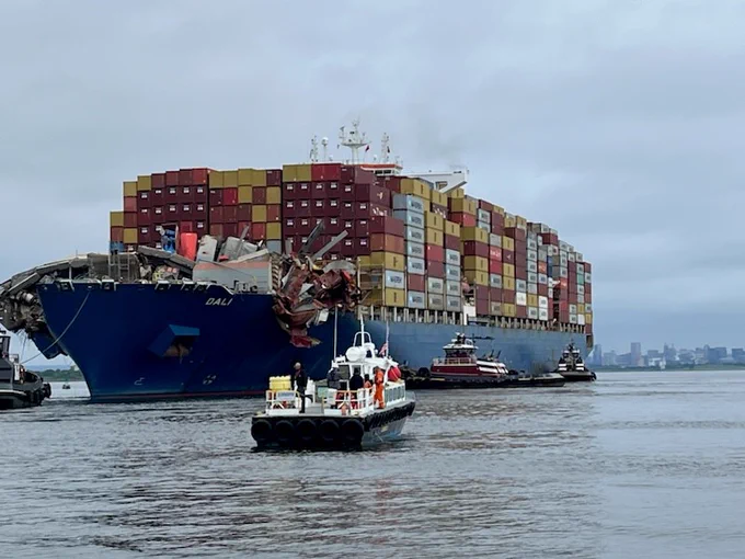 The Dali cargo ship is hauled away from the site of its crash into the Francis Scott Key Bridge.