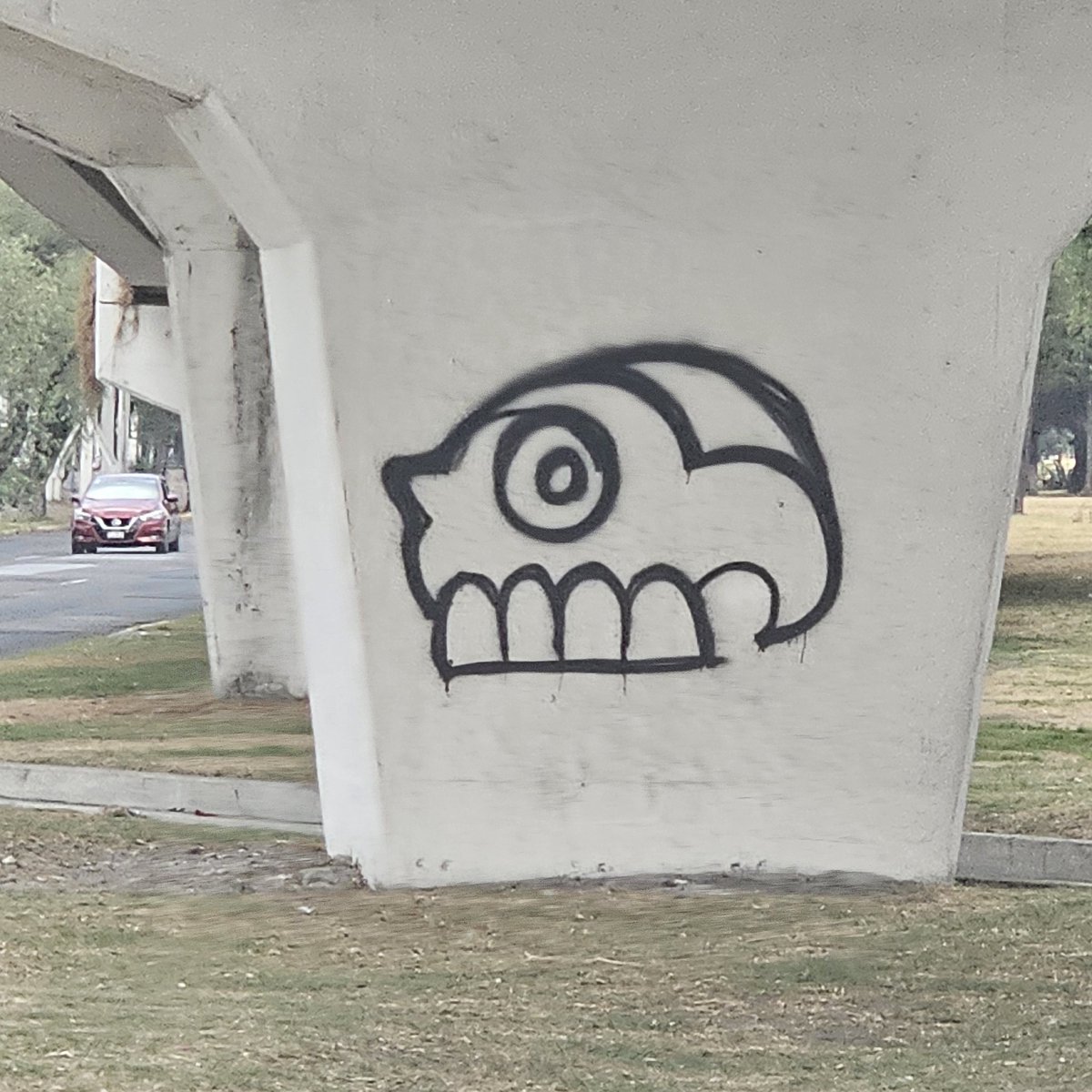 Un graffiti sencillo, inspirado en Mesoamérica. Un cráneo, símbolo de Miquiliztli la voz #náhuatl que designa «la muerte», adorna una columna de un puente.