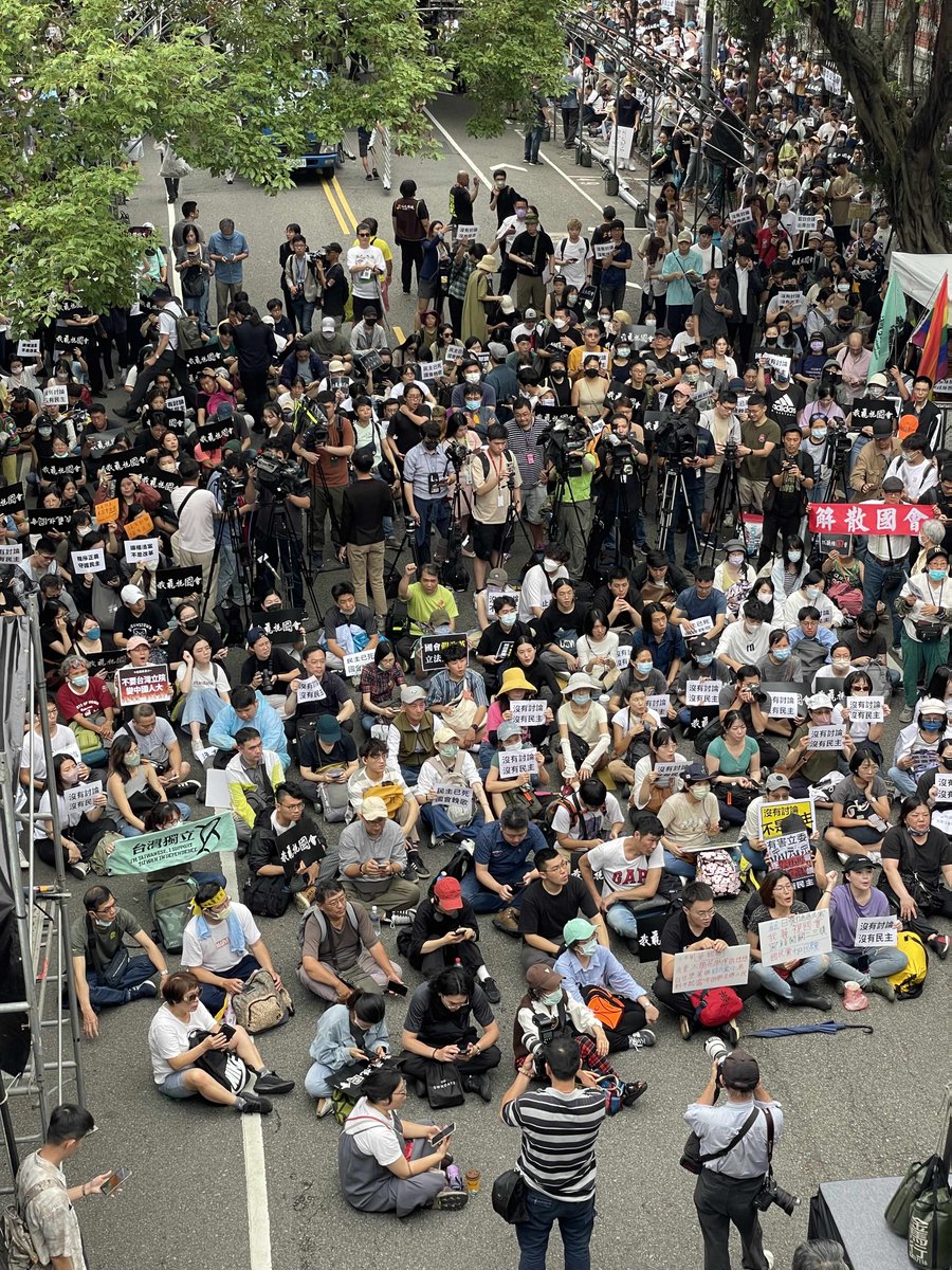 DemesDavid's tweet photo. The KMT continues to push its controversial bills expanding the LY's power through parliament. To prevent the DPP from blocking the procedures, the KMT has fortified itself on the podium and is reverting to voting by show of hand. Meanwhile, protesters keep gathering outside. https://t.co/Z1GJvC6cHT