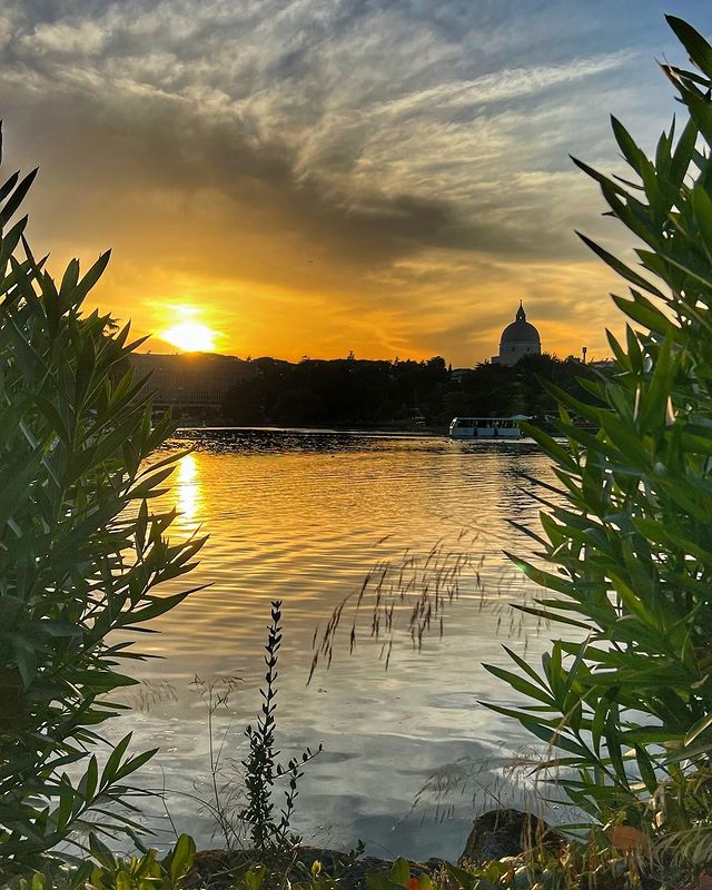 La cupola della Basilica dei Santi Pietro e Paolo e il laghetto dell'Eur nella luce di un tramonto dorato... The dome of the Basilica of Saints Peter and Paul and the Eur pond in the light of a golden sunset... 📸 IG meraviglie_di_roma #VisitRome