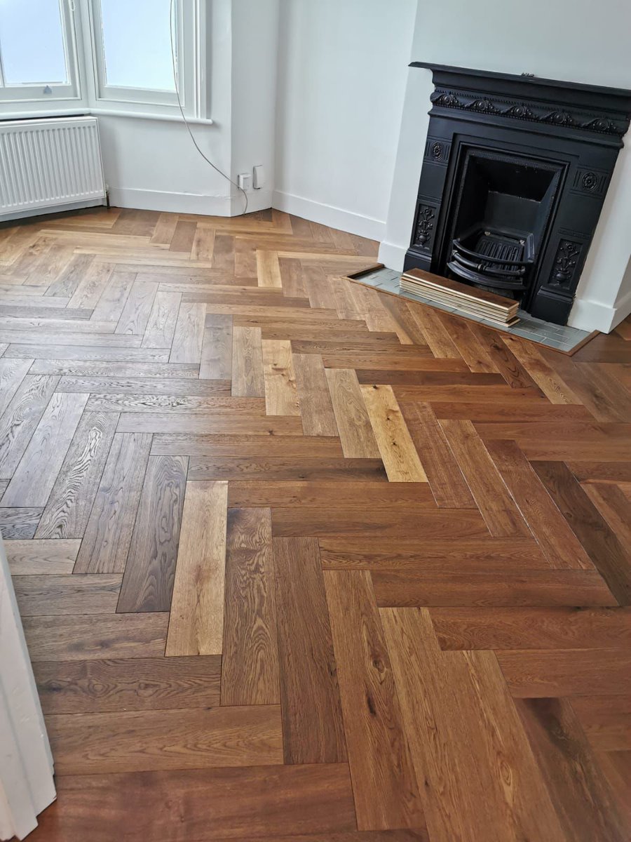 Living space transformation with a timeless Classic, the Smoked Oak parquet wood flooring. Perfectly fitted around the fireplace, it adds warmth and sophistication to your home. Discover the difference with Brilliant Wood Flooring. #InteriorInspiration #BrilliantWoodFlooring