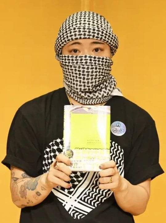 A Japanese writer wears a keffiyeh and the Palestinian flag while winning a literary award The young Japanese writer Ota Stephanie Kanto attended the ceremony to receive the Japanese Yukio Mishima Award wearing a keffiyeh and a T-shirt bearing the Palestinian flag.