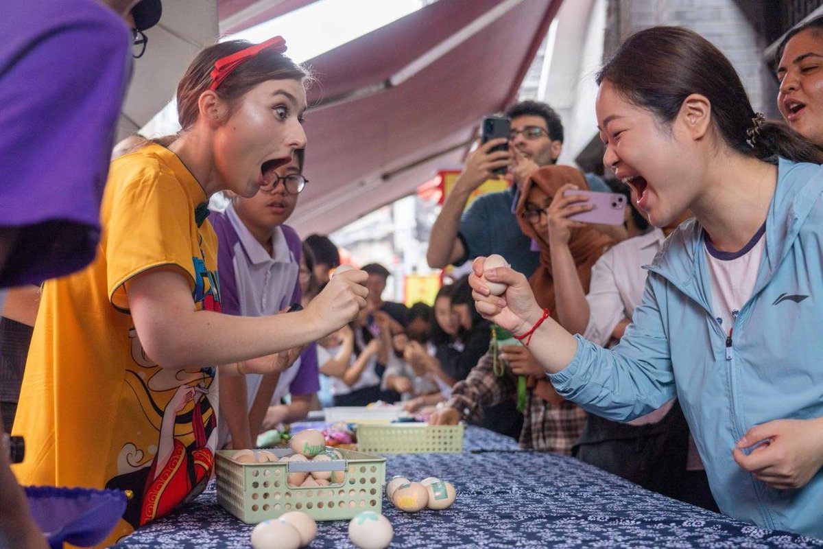 International and Chinese youth gathered at Zouma Ancient Town for an immersive experience of China's “The Beginning of Summer.” Activities included traditional customs like egg fighting, poetry sessions, and farming.  #CulturalExchange #Chongqing