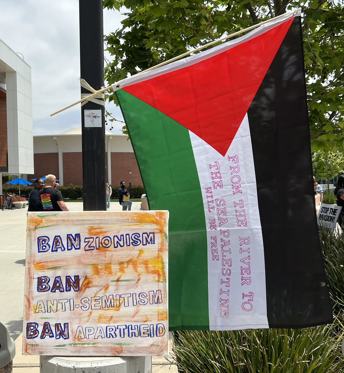 Palestine flag with the message “FROM THE RIVER TO THE SEA PALESTINE WILL BE FREE” flies next to a sign at the Teach-In for Palestine. #eccunion #elcaminocollege