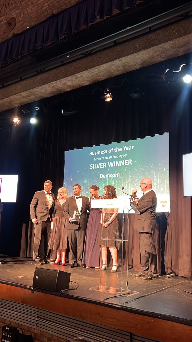The atmosphere is electric! @DEMCOM_UK have just secured the silver win in the Business of the year more than 50 employees! #SMEEly