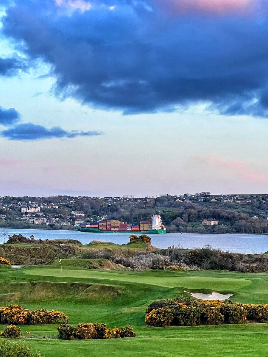 A ship sailing down the harbour past the 9th green and 5th tee.