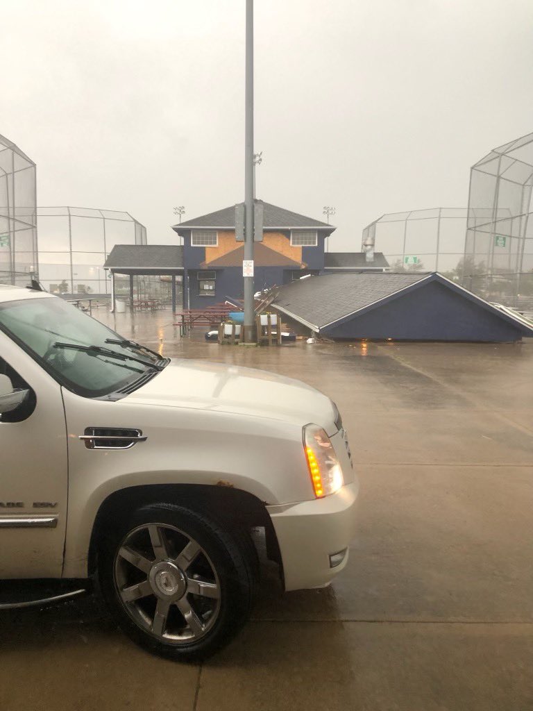 Damage in Urbandale from severe weather shows a tree on top a home along Beverly Drive & a portion of the overhang structure ripped away at the UGRA softball complex @WHO13news.