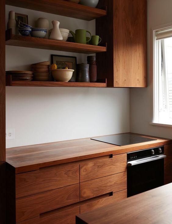 'A small apartment kitchen with rich walnut cabinetry'