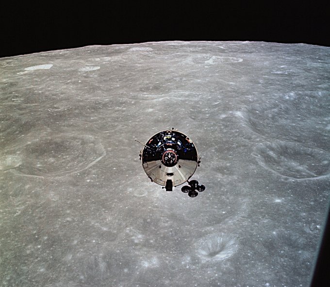AS10-27-3873 (22 May 1969) --- The Apollo 10 Command and Service Modules (CSM) are photographed from the Lunar Module (LM) after CSM/LM separation in lunar orbit. The CSM was about 175 statute miles east of Smyth's Sea and was above the rough terrain which is typical of the lunar far side. The eastward oblique view of the lunar surface is centered near 105 degrees east longitude and 1 degree north latitude. The horizon is approximately 600 kilometers (374 statute miles) away. Numerous bright craters and the absence of shadows show that the sun was almost directly overhead when this photograph was taken.