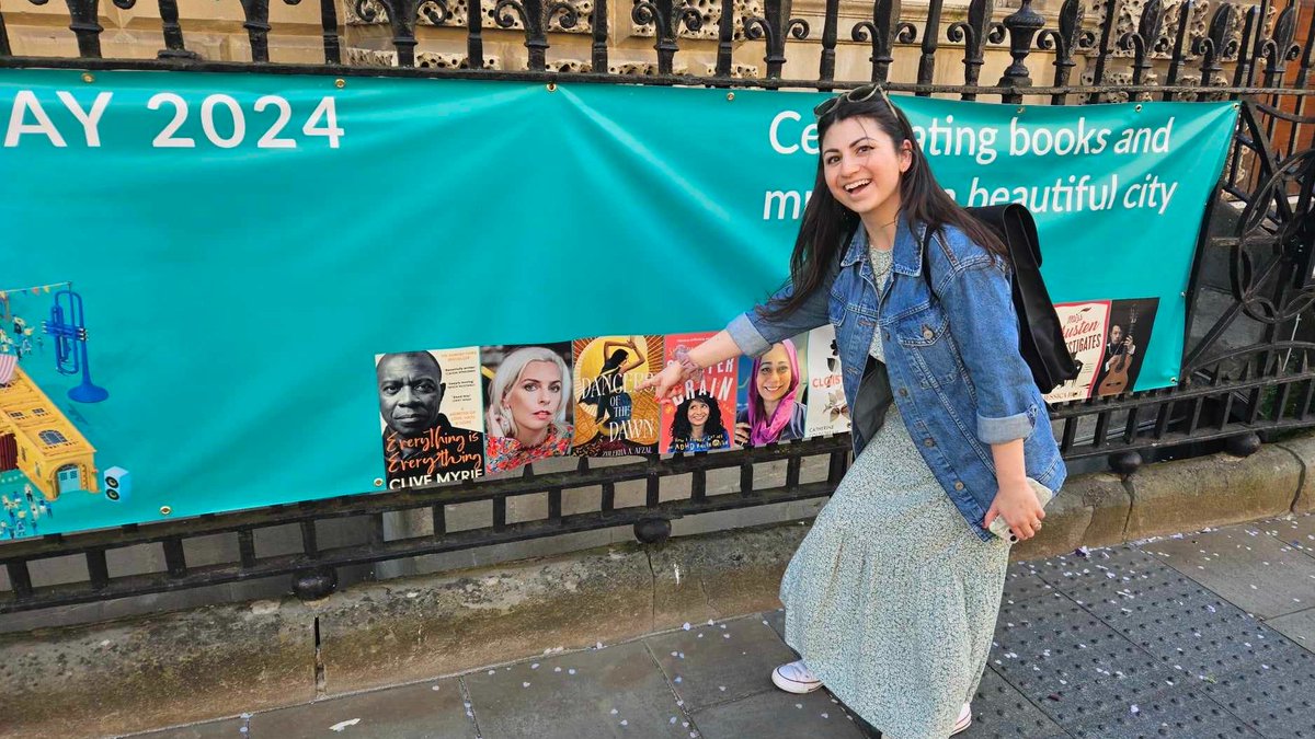 I'm so excited to be chatting with the wonderful @joannanadin tomorrow about my YA fantasy debut, #DancersOfTheDawn, @waterstonesbath. ☀️✨ Here's my excited face after spotting the cover on @TheBathFestival banner! 🥹🫶 bathfestivals.org.uk/the-bath-festi…