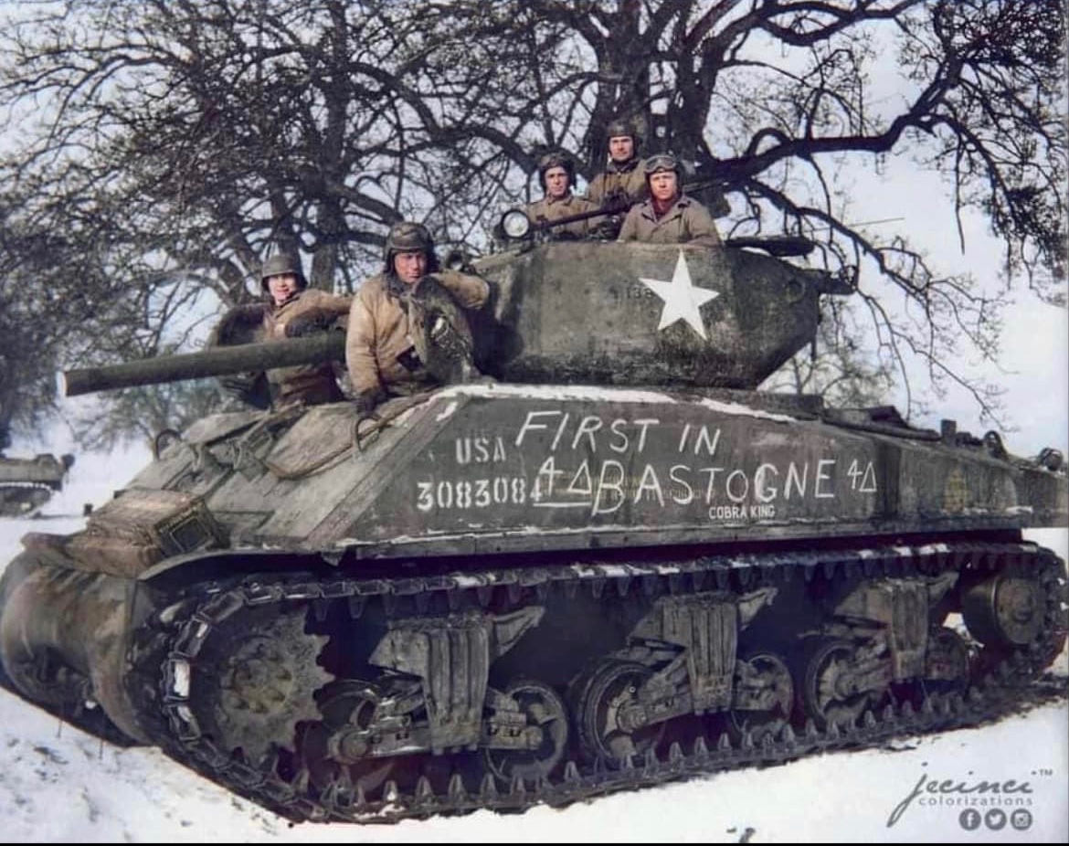 In December of 1944, the tank crew of “Cobra King” pose for a celebratory photo as the first tank to enter the Bastogne perimeter in relief of the 101st Airborne Division. 🪖