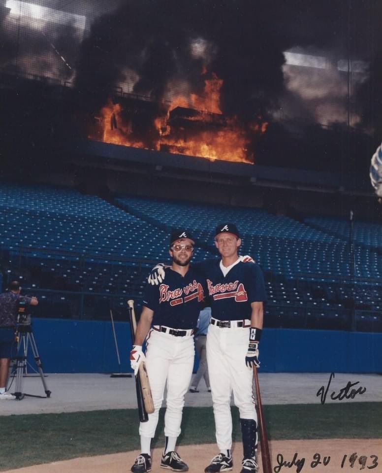 Fred McGriff, just acquired via trade from San Diego, is swinging such a hot bat that his arrival sets Fulton County Stadium on fire. Infielders Mark Lemke & Jeff Blauser are so exited to have Crime Dog in the lineup that they happily pose for a photo while the press box burns.