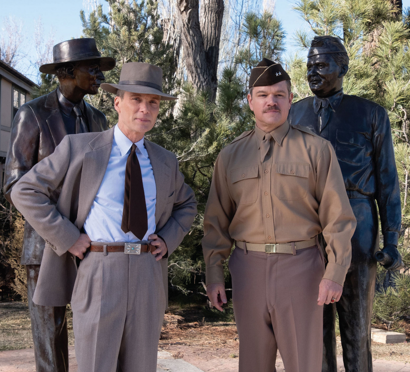 Cillian Murphy and Matt Damon stand in front of the bronze statues of their characters, J. Robert Oppenheimer and General Leslie Groves, outside Fuller Lodge in Los Alamos, New Mexico.