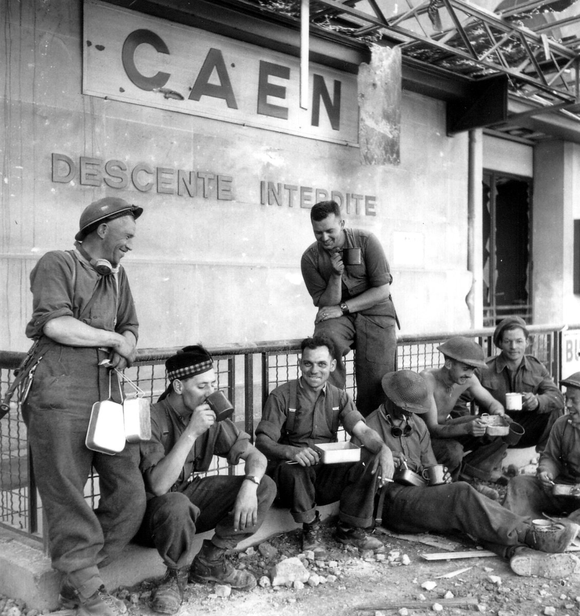 [#jeudiphoto 📸] Une photo particulière aujourd'hui, celle de ces soldats canadiens du régiment Stormont Dundas et Glengarry Highlanders déjeunant dans la #gare de Caen endommagée par les combats, quelques semaines après le débarquement #dday que nous commémorons aujourd'hui 🇨🇦