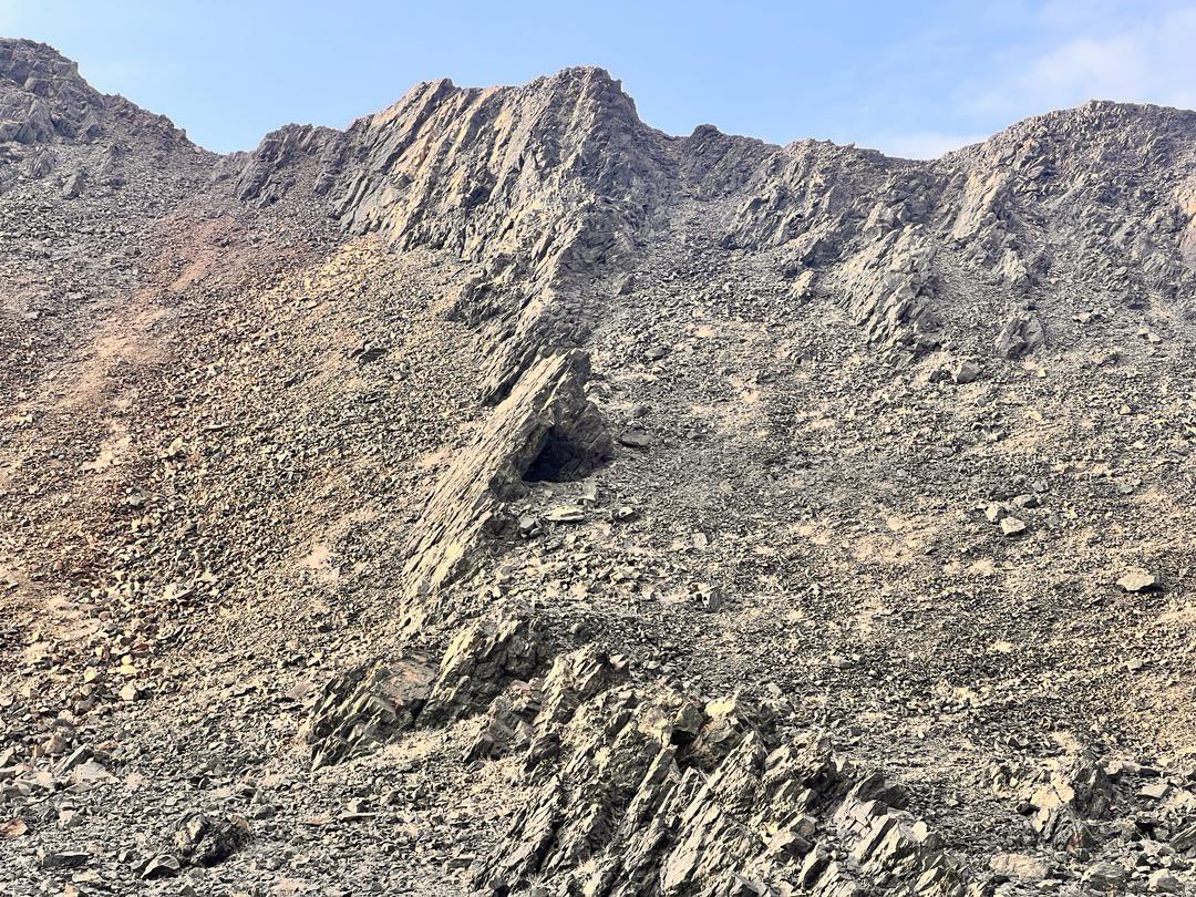 This amphibolite outcrop is weathered, black in colour, and has fractures.
This rock is located about 1 km from the coast of Xiis town, near the Raduuda Mountains (Dhoobo).

Geological Feature: Rock Outcrop.
Type of Rock: Amphibolite (Metemorphic). 

#SomalilandGeologicFeatures