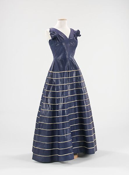 This week's #ThirtiesThursday garment is this rare 1939 evening dress designed by Madame Grès for Alix. Made from dark blue stiff glazed cotton, the bodice features gathered cap sleeves that presages her later work with fabric draping. @metmuseum collection #Fashionhistory #dress