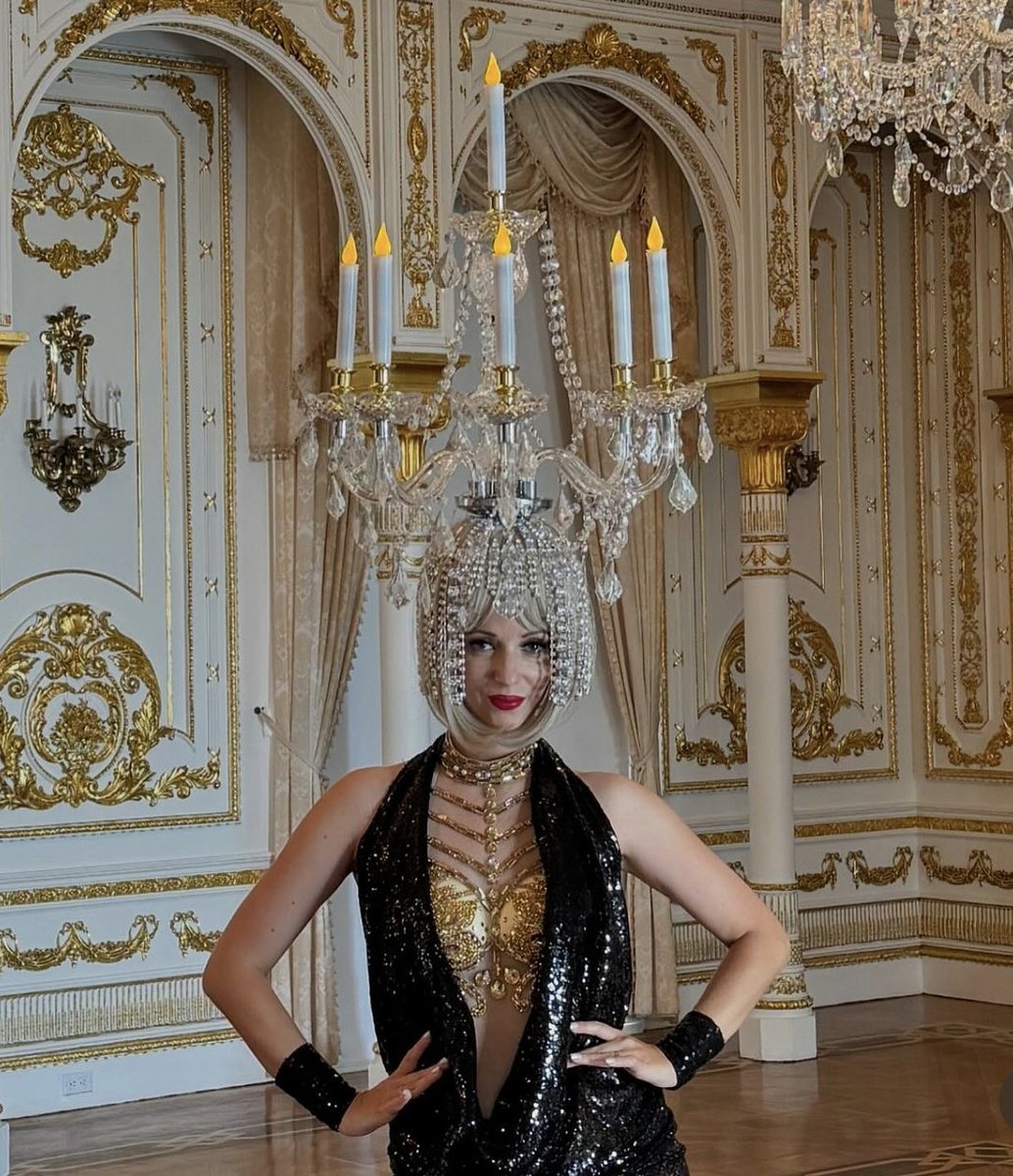 Trump is just like us! Who doesn’t have an entertainer wearing a chandelier on their head in their home?