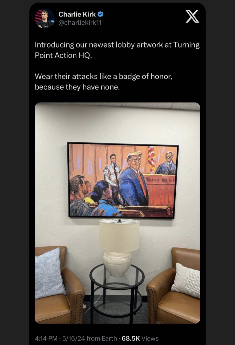 Charlie Kirk hangs up a picture of Judge Merchan in his lobby.