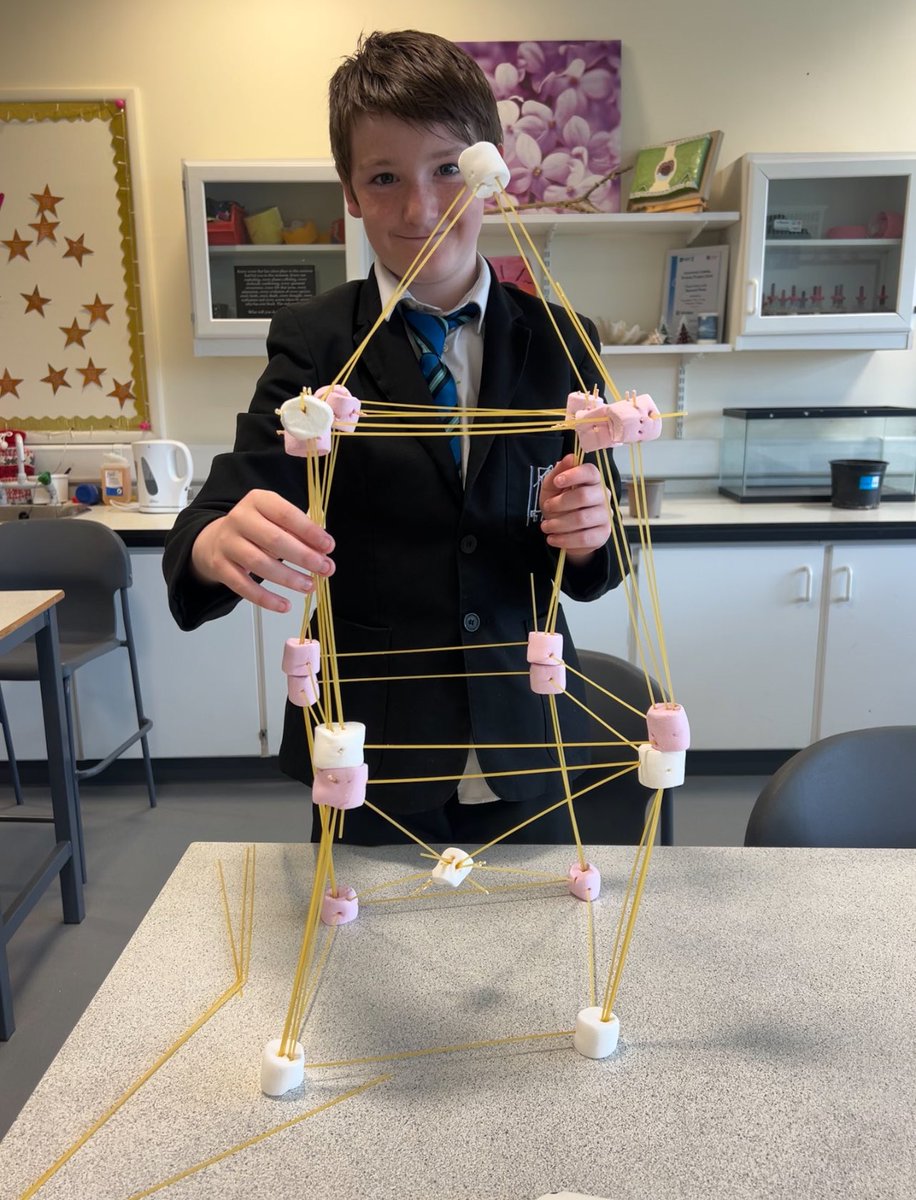 WoodfarmHigh's tweet photo. Steven in S1 has been working hard to complete his Young STEM Leader Award in Science.  Today he taught Mrs Bell how to build a spaghetti and marshmallow tower.  They will evaluate the trial construction and try to improve the design for their next tower! #WHSScience https://t.co/pbByGp2Dp3