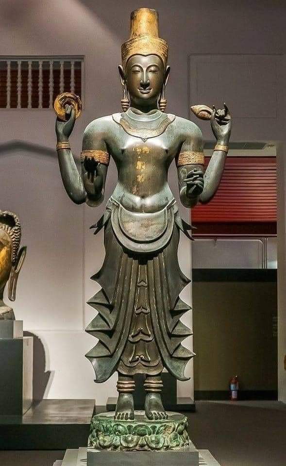 Sri Vishnu, 14th Century, Sukhotai Kingdom - Thailand This colossal (8' high), chaturbhuja Sri Vishnu holds Chakra and Shankha and wears a well pleated lower garment. This statue is made of bronze with gilt overlay. Almost the whole of SE Asia was