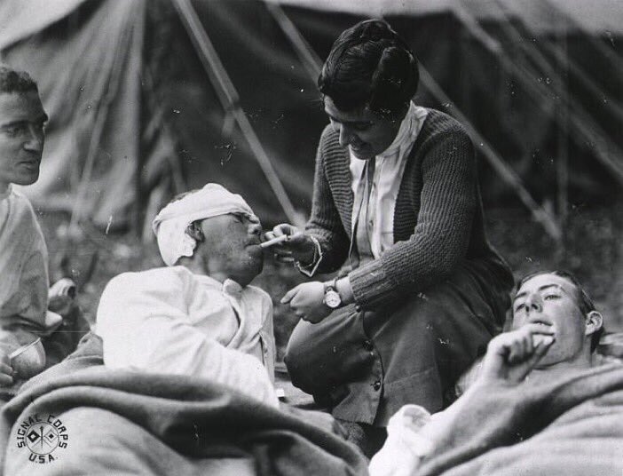 Red Cross worker Miss Anna Rochester lights the cigarette of injured U.S. soldier at evacuation camp #WWI #histmed #historyofmedicine #pastmedicalhistory