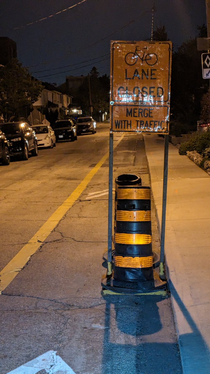 Hi @311Toronto this sign 'closing' the counterflow bike lane northbound on Winona at Ava Rd., makes no sense. There isn't anything to justify the closure AND 'merging' with traffic means meeting head-on southbound traffic. Can this be explained, fixed or removed? Thanks. #bikeTO