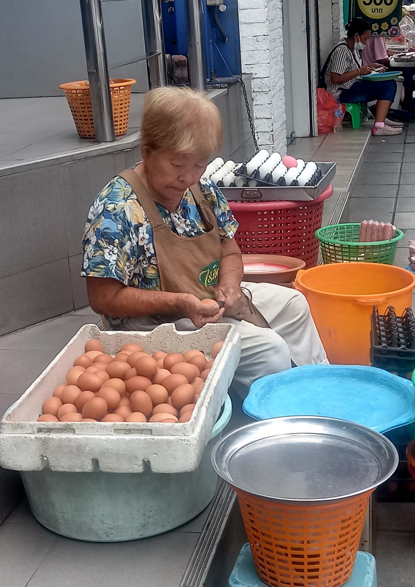 This Thai vendor is scratching the shells of chicken eggs. To make her eggs look good. Charoen Krung Road Bangkok, Thailand