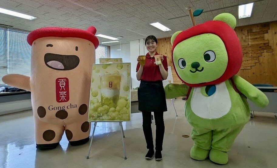 Nagano Prefecture mascot Arukuma, a rambling green bear with an apple hat, meets the Gong Cha mascot, a cup of bubble tea. (Gong Cha are releasing a new tea with grapes from Nagano.)