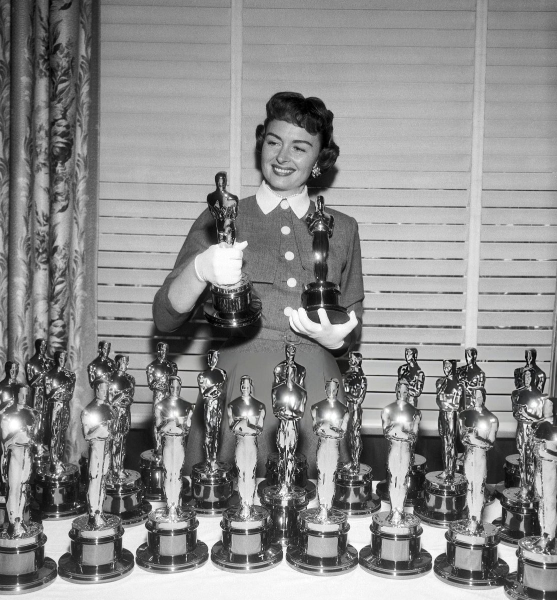 Donna Reed, who won an Oscar in 1954 for From Here to Eternity, shown here examining the Oscars that were presented to the winners at the 27th Academy Awards held on March 30, 1955. Reed presented Edmond O'Brien his Oscar for his role in The Barefoot Contessa, March 25, 1955.