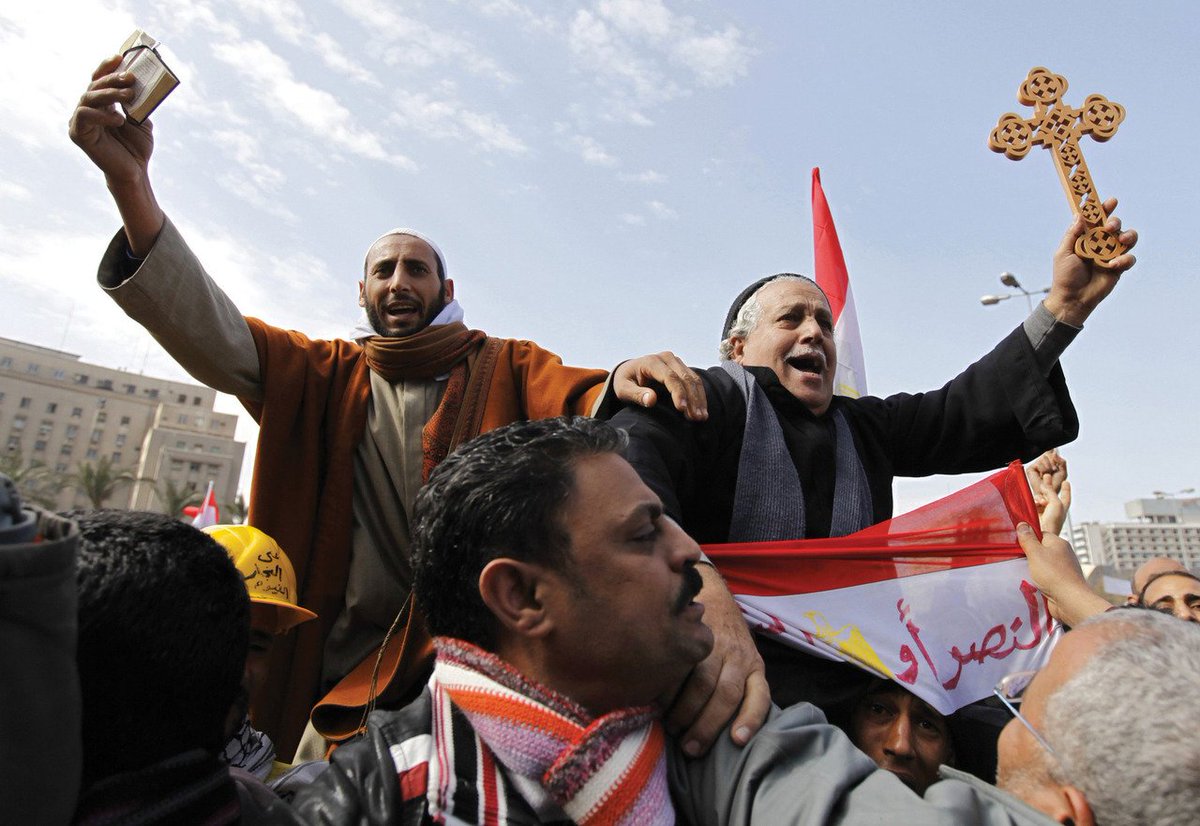 A Muslim holding the Quran and a Coptic Christian holding a cross are carried by opposition supporters in Tahrir Square, Cairo, on 6 February 2011. 🇪🇬

📷: Dylan Martinez.