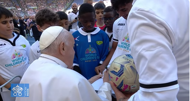 Pope Francis made first kick for a friendly mini-match between kids and retired Italian soccer stars. He signed the ball and jerseys at the first World Children's Day at Rome's Olympic Stadium.