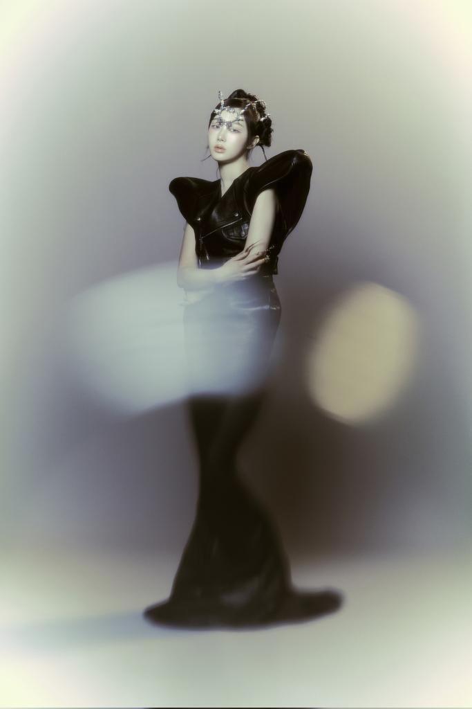 uchisagaeri's tweet photo. she stands poised in a sculptural black gown that flows seamlessly to the ground, accentuating her elongated silhouette. her serene expression, combined with the intricate headpiece adorning her forehead, gives her an almost regal presence. https://t.co/ncSoNSi3jg