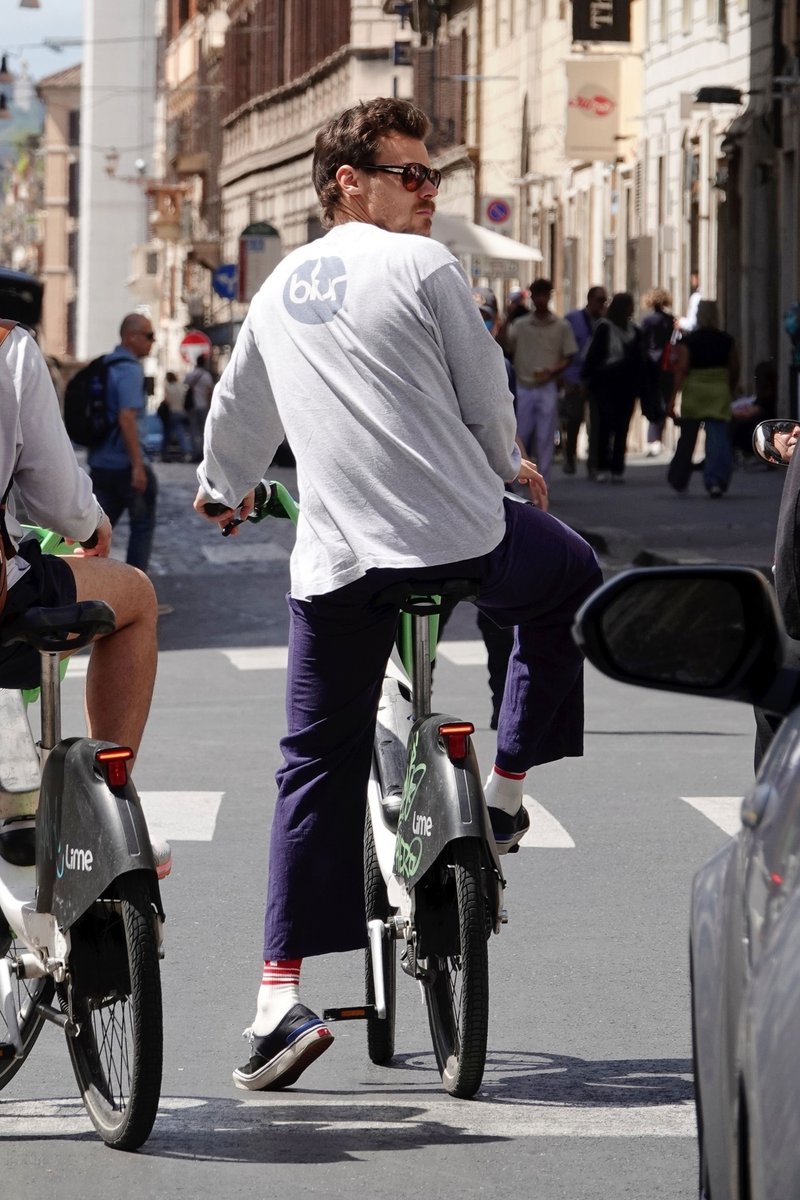 Harry riding a Lime bike with a friend of his in Italy recently.