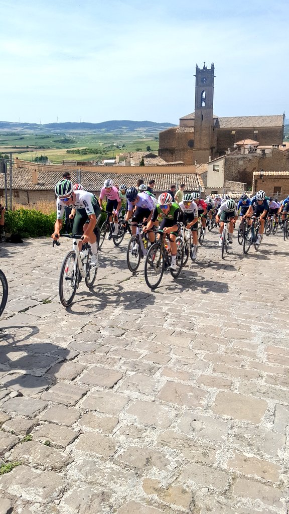 Por el muro hacia el Cerco de Artajona Gorka Ortega @GsportTeam  en cabeza. Pelotón a 20' comandado por Ilya @FilialCajaRural  que va cortándose #VN24 #VueltaNavarra2024