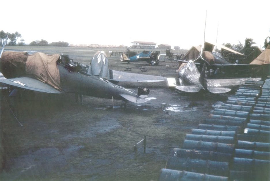 Maintenance area at Clark Field showing several damaged P-35As, with a P-26 Peashooter in the background.