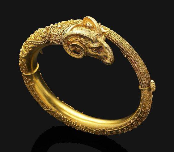 Un antiguo brazalete de oro del renacimiento bizantino, de diseño con bisagras e inspiración oriental, la cabeza de carnero de oro texturizado termina en la banda altamente decorada de cuentas y detalles de cuerda retorcida #arte