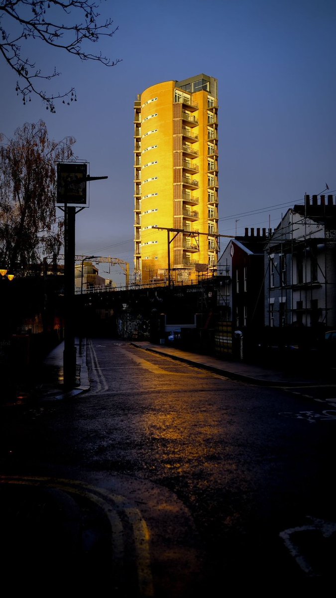 The golden glow of a council tower block in the evening sun. Hackney