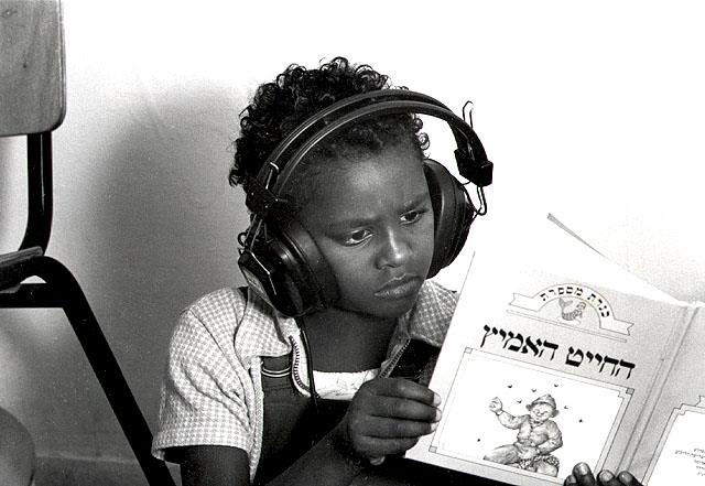New Bete-Israel girl from Ethiopia listen to a tape of children's stories, Safed, Israel, 1985
